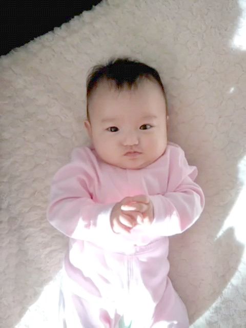 可愛的小寶貝躺在床上曬著太陽